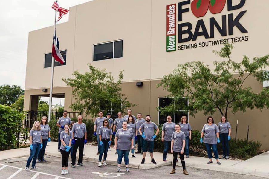 About Our Agency - Portrait of the Team of at Barnard Donegan Insurance Company Posing in Front of a Food Bank After Volunteering Their Time to Give Back to Their Community