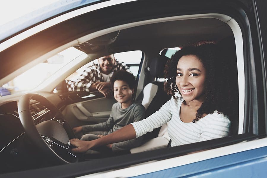 Personal Insurance - Closeup of a Family of Father, Mother and Son Smiling in Their New Car